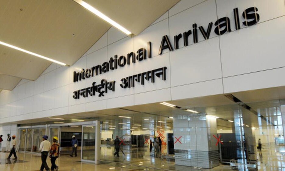 Indira Gandhi International Airport (DEL) Terminal 3 arrivals hall, showing the modern gold Buddha hand mudra installations and clean passenger walkways for international travelers.