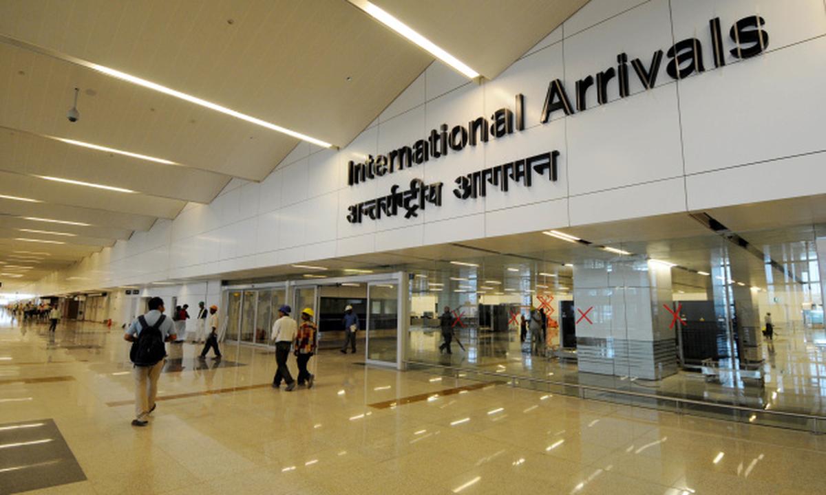 Indira Gandhi International Airport (DEL) Terminal 3 arrivals hall, showing the modern gold Buddha hand mudra installations and clean passenger walkways for international travelers.